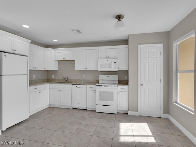 kitchen featuring white appliances, white cabinets, sink, light stone countertops, and light tile patterned floors