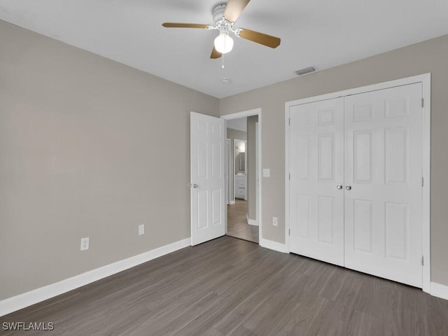 unfurnished bedroom featuring ceiling fan, dark hardwood / wood-style flooring, and a closet