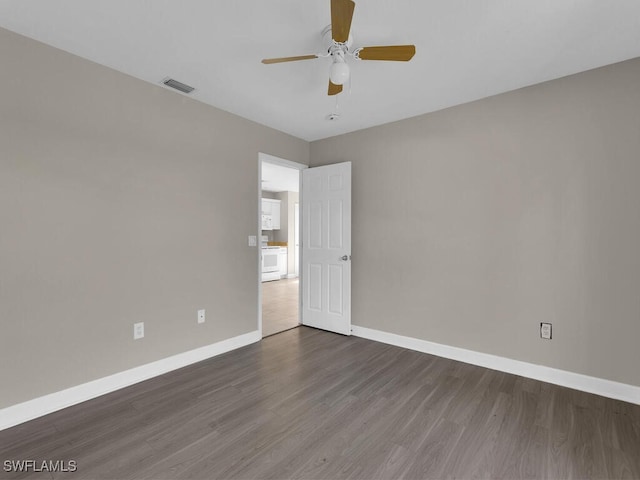 spare room with ceiling fan and dark hardwood / wood-style flooring