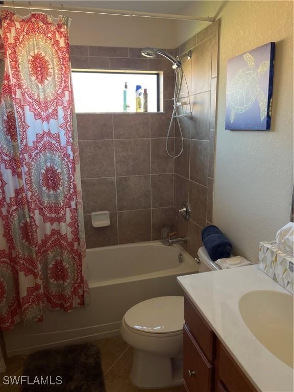 full bathroom featuring tile patterned flooring, vanity, toilet, and shower / bath combo with shower curtain