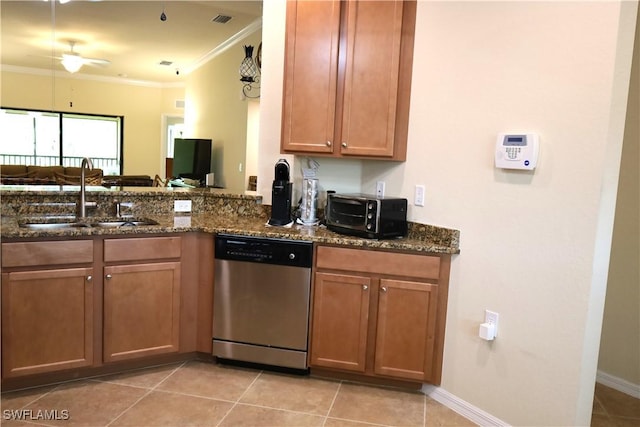 kitchen with dark stone counters, dishwasher, crown molding, and a sink