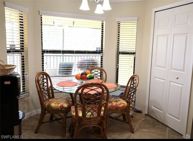 dining room featuring tile patterned floors, baseboards, and a notable chandelier