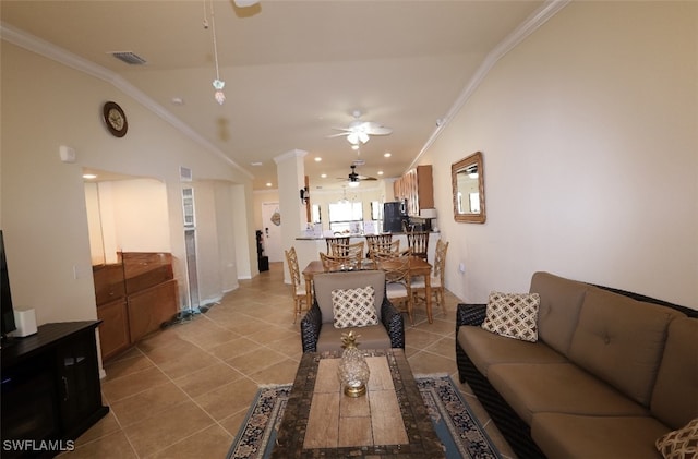 living room with light tile patterned flooring, a ceiling fan, ornamental molding, and vaulted ceiling
