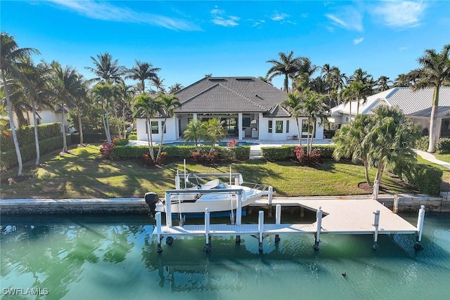 view of dock with a lawn and a water view