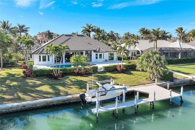 rear view of property with a lawn, a patio area, and a water view