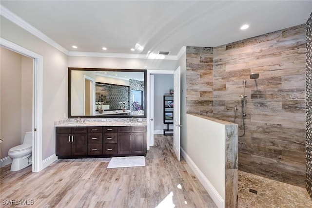 bathroom with vanity, crown molding, a shower, hardwood / wood-style floors, and toilet