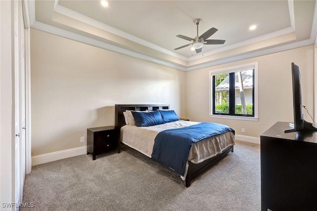 bedroom featuring ornamental molding, a tray ceiling, ceiling fan, and light colored carpet