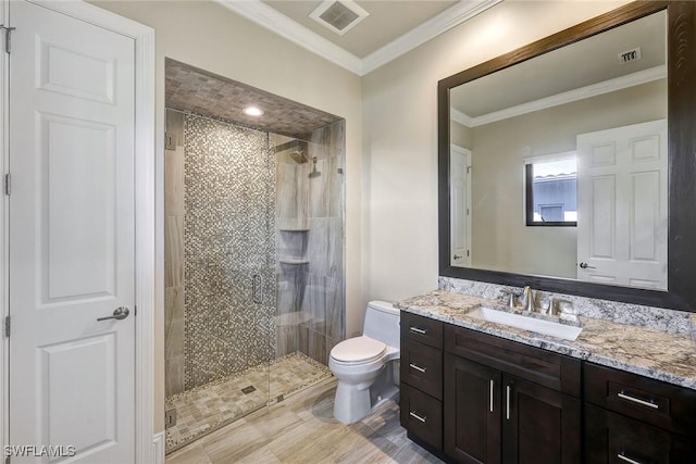 bathroom featuring vanity, toilet, a shower with shower door, and crown molding