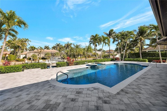 view of swimming pool featuring an in ground hot tub and a patio