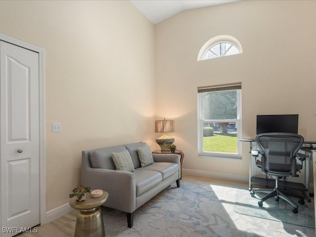 office with high vaulted ceiling, wood finished floors, a wealth of natural light, and baseboards