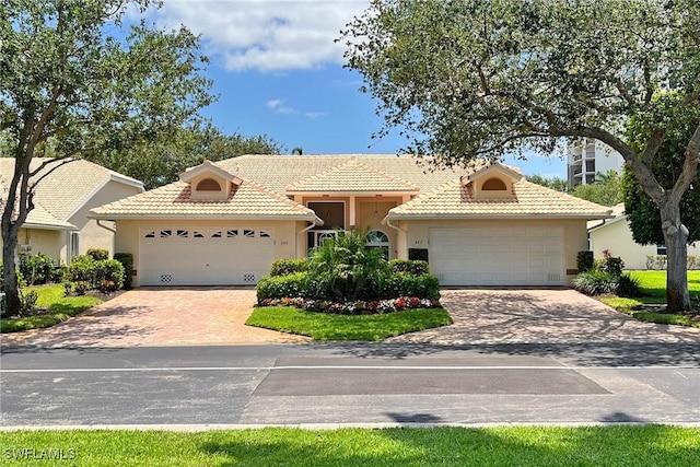 682 Wiggins Bay Dr, Naples, FL 34110 - view of front facade with a garage, a tile roof, stucco siding, and driveway