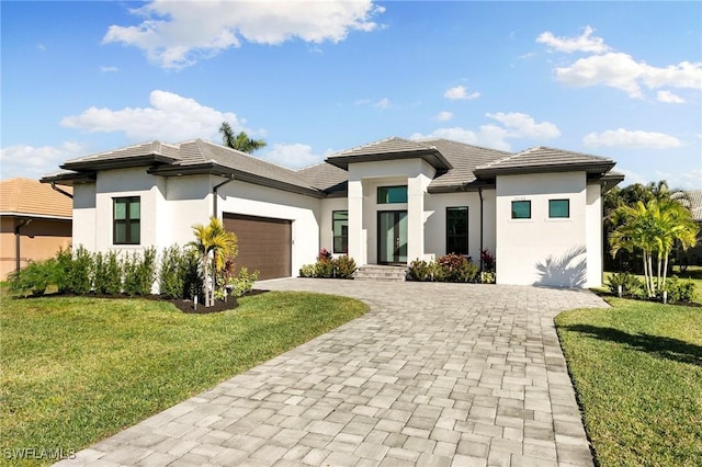 prairie-style home with a front lawn and a garage