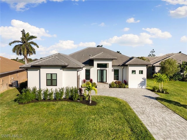 view of front of house featuring central air condition unit and a front lawn