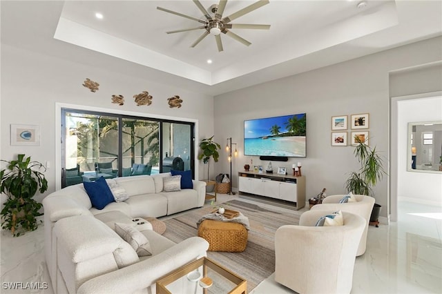 living room with ceiling fan and a tray ceiling