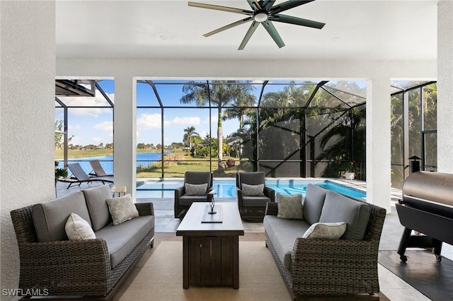 sunroom / solarium with a water view, a pool, and ceiling fan