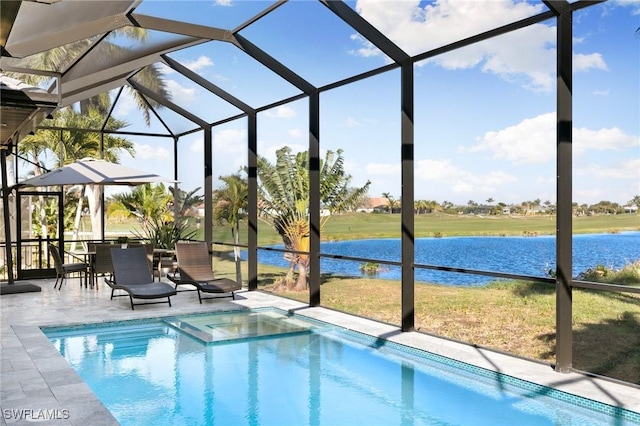 view of pool with glass enclosure, a patio area, and a water view