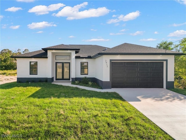 prairie-style house with a garage, stucco siding, driveway, and a front yard