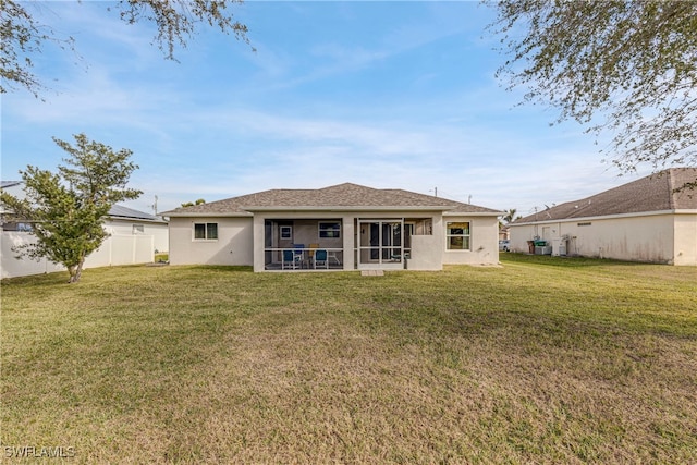 rear view of property featuring a sunroom and a lawn