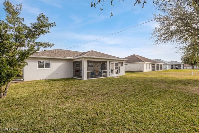 back of house featuring a yard and a sunroom