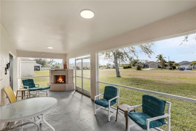 sunroom featuring exterior fireplace