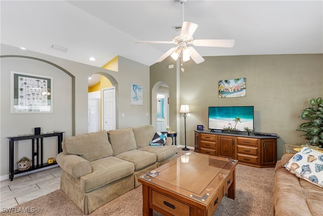 tiled living room with ceiling fan and vaulted ceiling