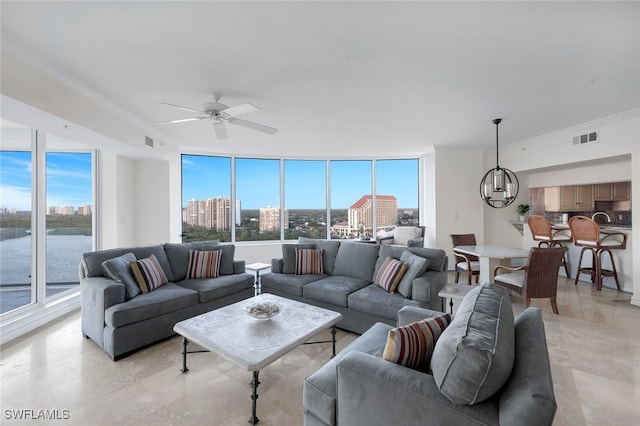 living room with visible vents, a city view, crown molding, and ceiling fan