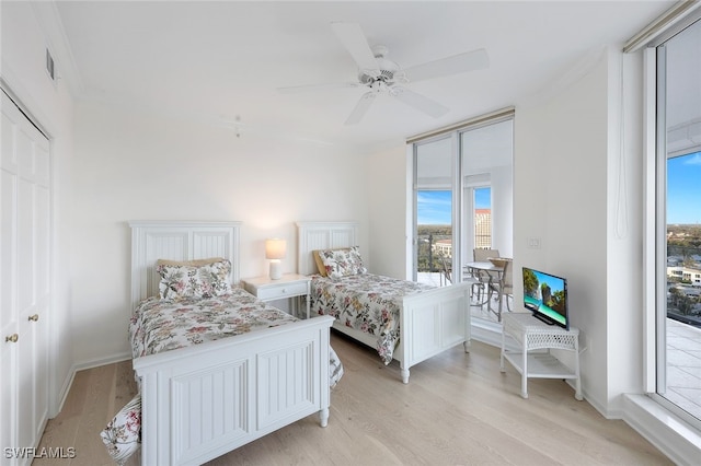 bedroom featuring visible vents, light wood-style flooring, a ceiling fan, and access to outside