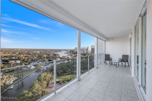 unfurnished sunroom featuring a city view and a water view