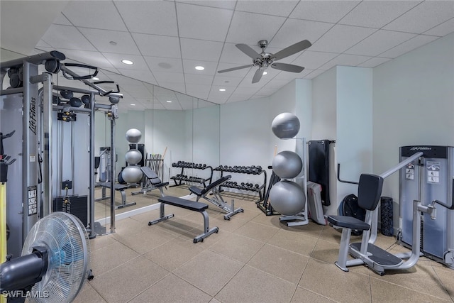 gym with a paneled ceiling and ceiling fan