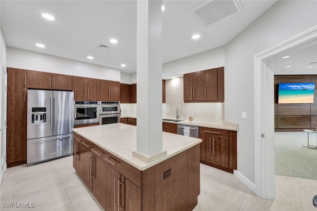 kitchen featuring visible vents, appliances with stainless steel finishes, a center island, and a sink