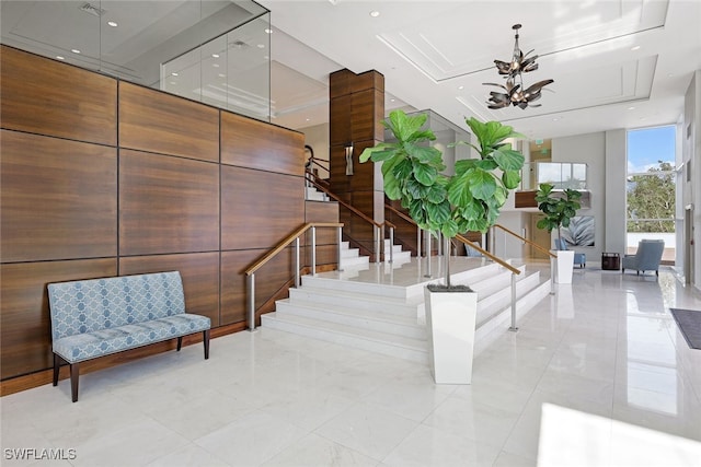 stairway featuring recessed lighting, a raised ceiling, an inviting chandelier, and floor to ceiling windows