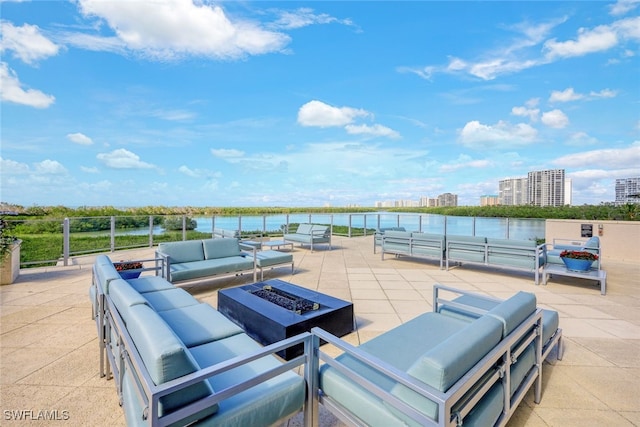 view of patio / terrace with an outdoor living space with a fire pit and a water view