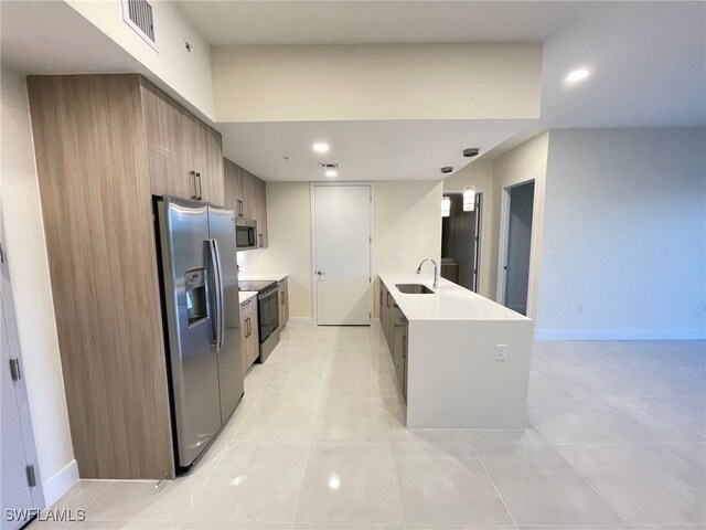 kitchen featuring sink, decorative light fixtures, stainless steel appliances, and light tile patterned floors