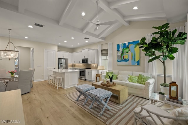 living room featuring vaulted ceiling with beams, ceiling fan with notable chandelier, and light hardwood / wood-style flooring