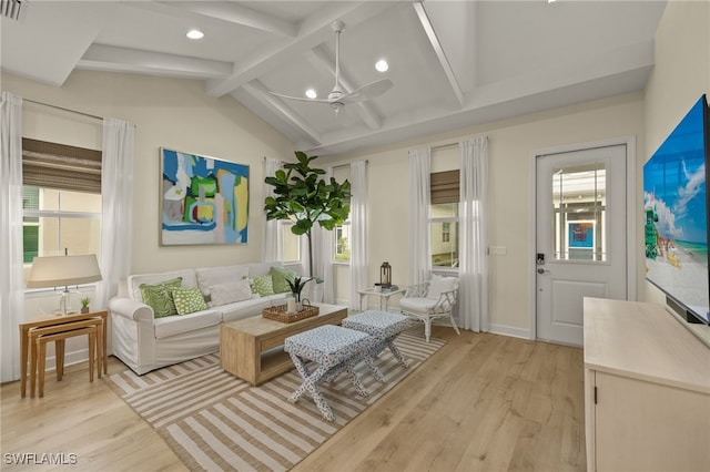 living room with ceiling fan, a wealth of natural light, vaulted ceiling with beams, and light wood-type flooring