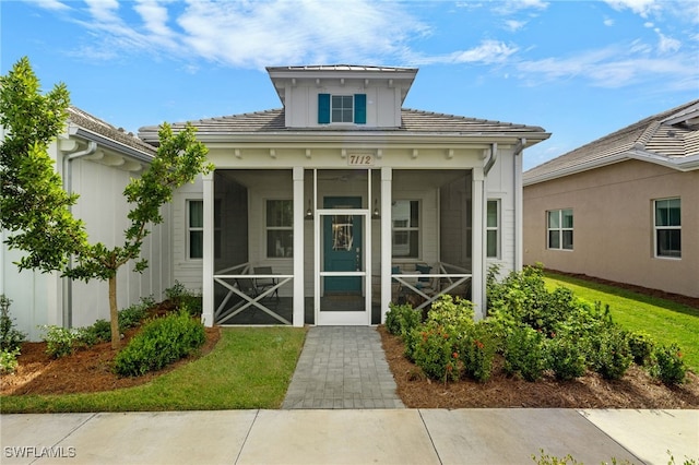 view of front facade featuring a front yard and a sunroom