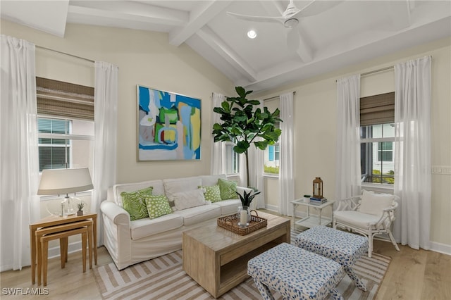 living area featuring ceiling fan, a healthy amount of sunlight, light wood-type flooring, and vaulted ceiling with beams