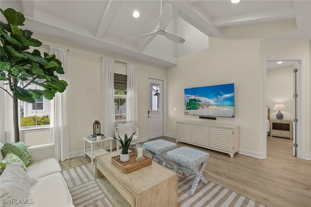 living room with beam ceiling, ceiling fan, heating unit, and light hardwood / wood-style floors