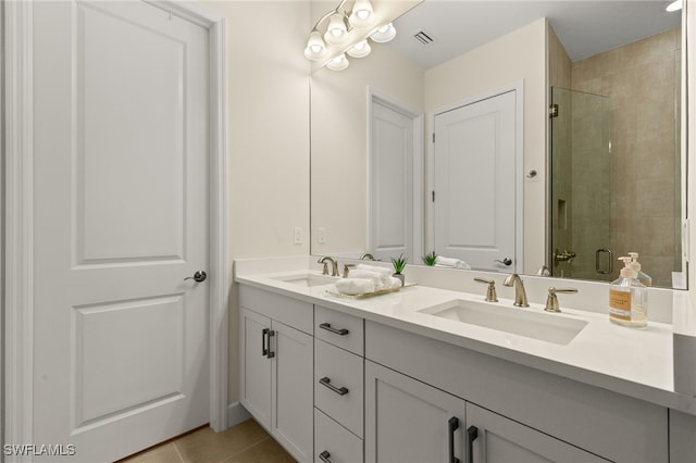 bathroom with tile patterned flooring, a shower with shower door, and vanity