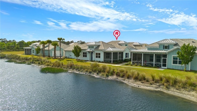 back of property with a sunroom and a water view