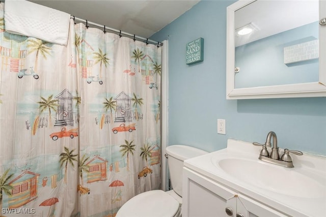 bathroom with walk in shower, vanity, and toilet