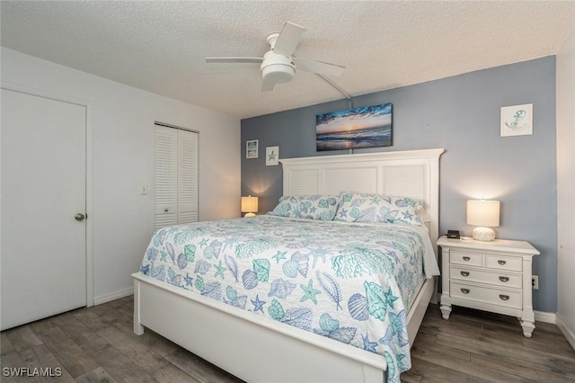 bedroom with dark wood-type flooring, a textured ceiling, ceiling fan, and a closet