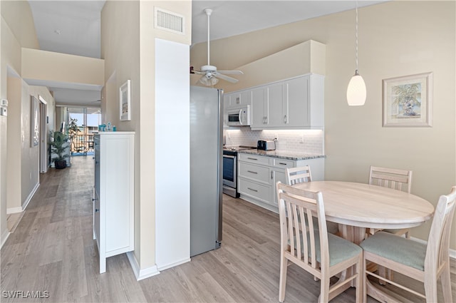 kitchen with tasteful backsplash, white cabinetry, ceiling fan, and appliances with stainless steel finishes