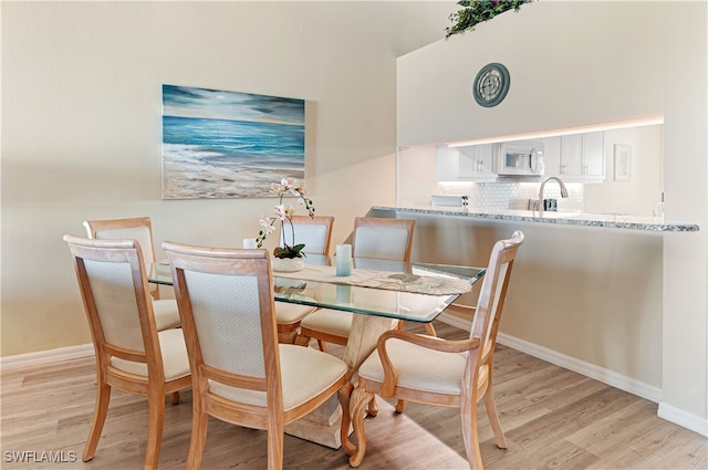 dining space with light hardwood / wood-style flooring and sink