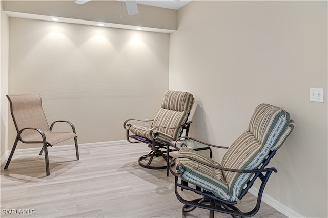 living area featuring ceiling fan and light hardwood / wood-style floors