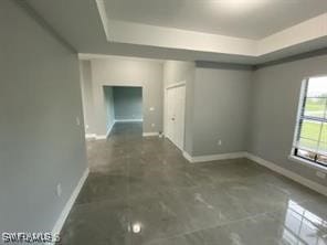 unfurnished room with a tray ceiling