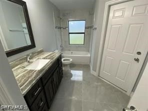 full bathroom with tiled shower / bath, vanity, and toilet