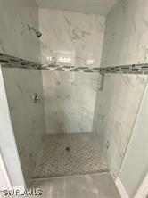 bathroom featuring a tile shower and tile patterned flooring