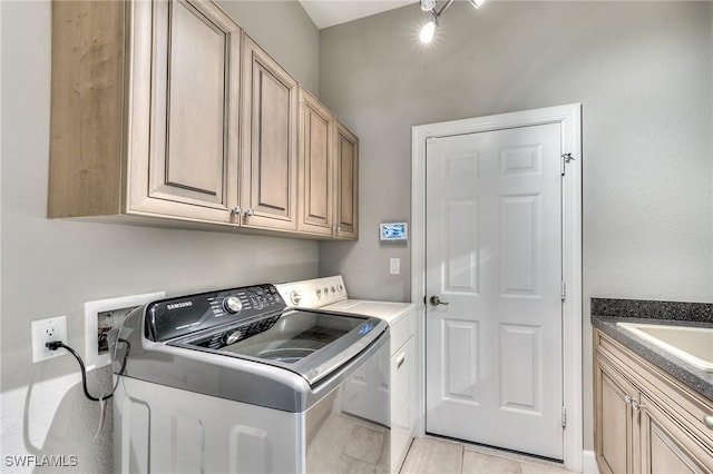 laundry room featuring washer and dryer, cabinets, sink, and light tile patterned floors