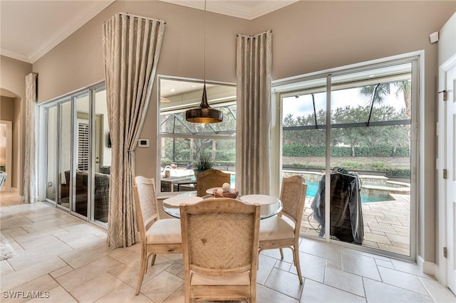 dining area featuring a high ceiling and crown molding